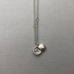 Meaning The tiniest locket, inscribed with the word "Be". To be; to inhabit or embrace a state of being. Invoke being at peace with yourself. Truly know, love, and accept your perfectly imperfect, delightfully authentic self.  “To be yourself in a world that is constantly trying to make you something else is the greatest accomplishment.” ~ Ralph Waldo Emerson  Details Locket measures approximately 1/4" in diameter. Hangs on a round cable chain Fastens with a lobster clasp