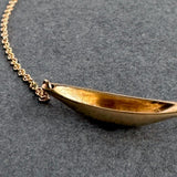 Gold necklace on a dark gray background