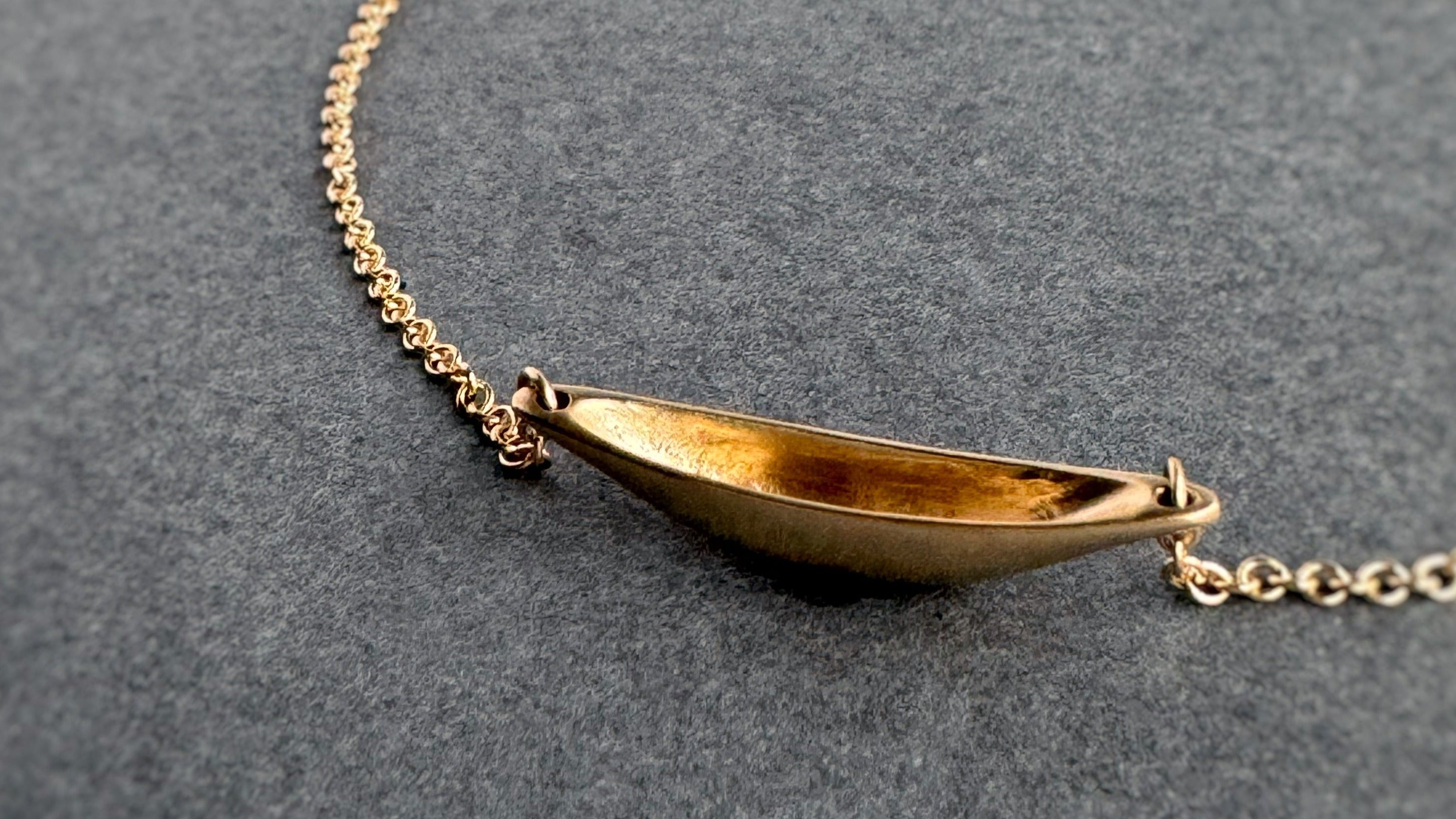 Gold necklace on a dark gray background