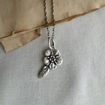 Forget Me Not Flower Charm, Sterling Silver on cream background