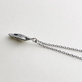 Sterling silver charm necklace, bird is in flight on cream background