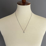 "be" charm necklace on model