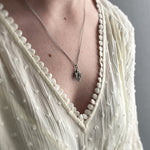 sterling silver sparrow necklace worn on model with white dress
